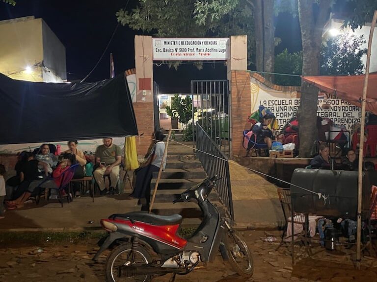 Padres acampan afuera de escuelas para garantizar cupos.